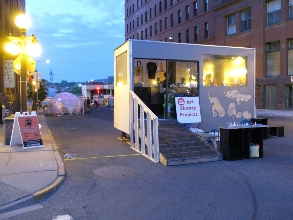 "Art Shanty Projects Disperse": Board Shanty, Snap Shot Shanty, ParaDICE, and Art Swap Shanty on Broadway St. in Lowertown.